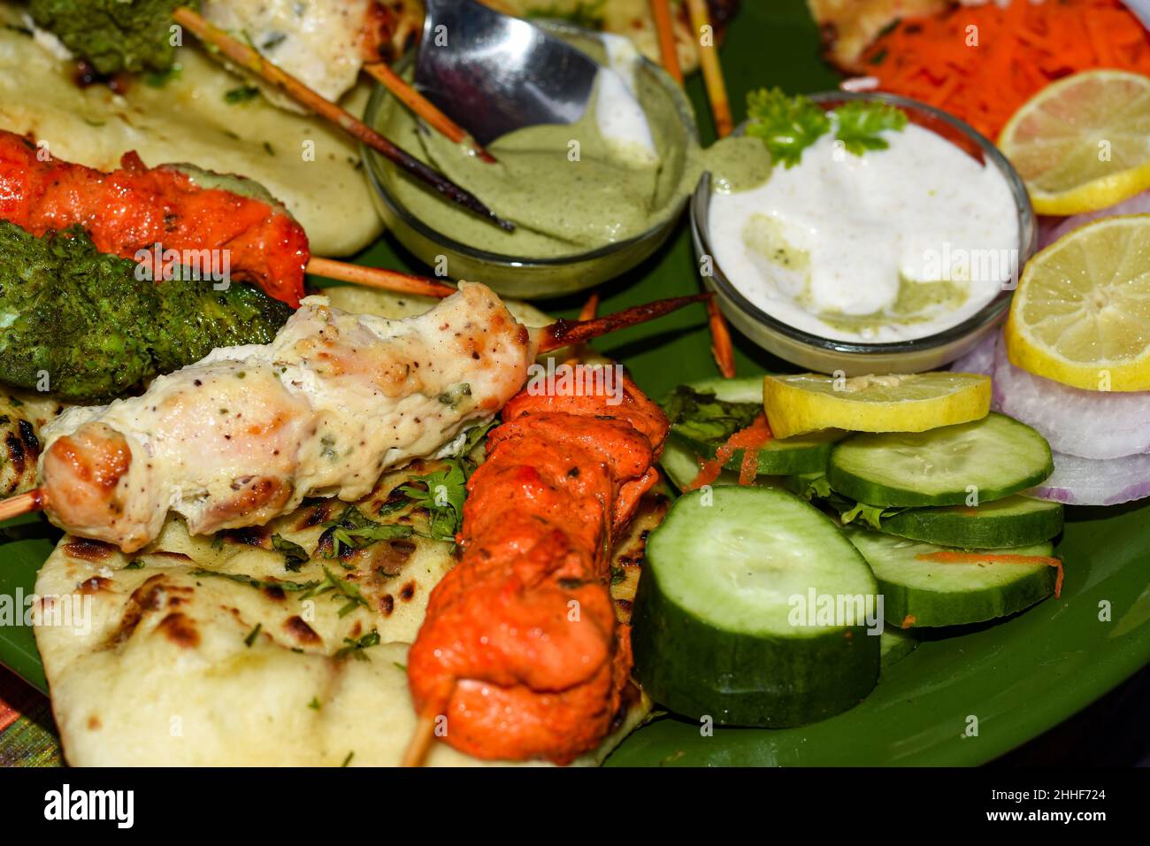 Pollo Reshmi Kebab con Naan burro, chutney di menta yogurt e insalata. Foto Stock