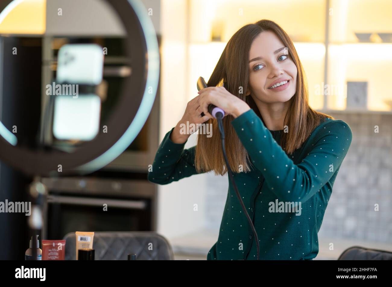 Giovane donna sorridente che mostra suggerimenti su haircare Foto Stock