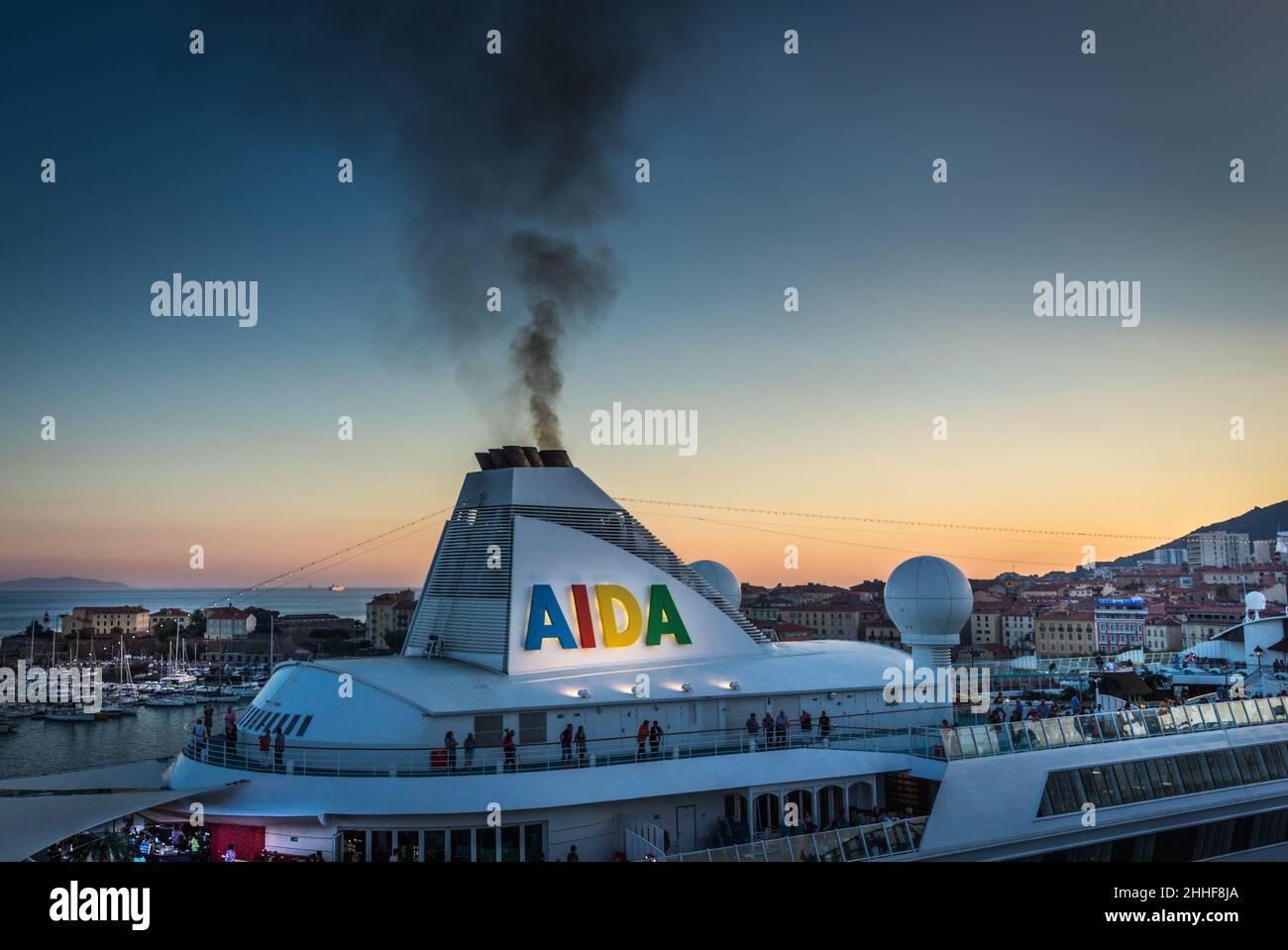 Ein Kreuzfahrtschiff im Hafen von Ajaccio bläst schädliche Abgase in den Abendhimmel Foto Stock