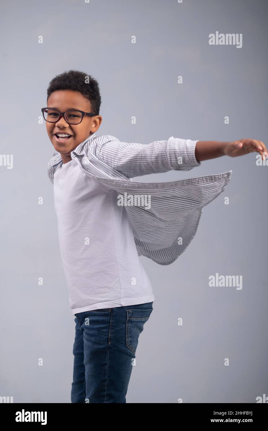 Ragazzo gioioso che allunga le braccia ai lati Foto Stock