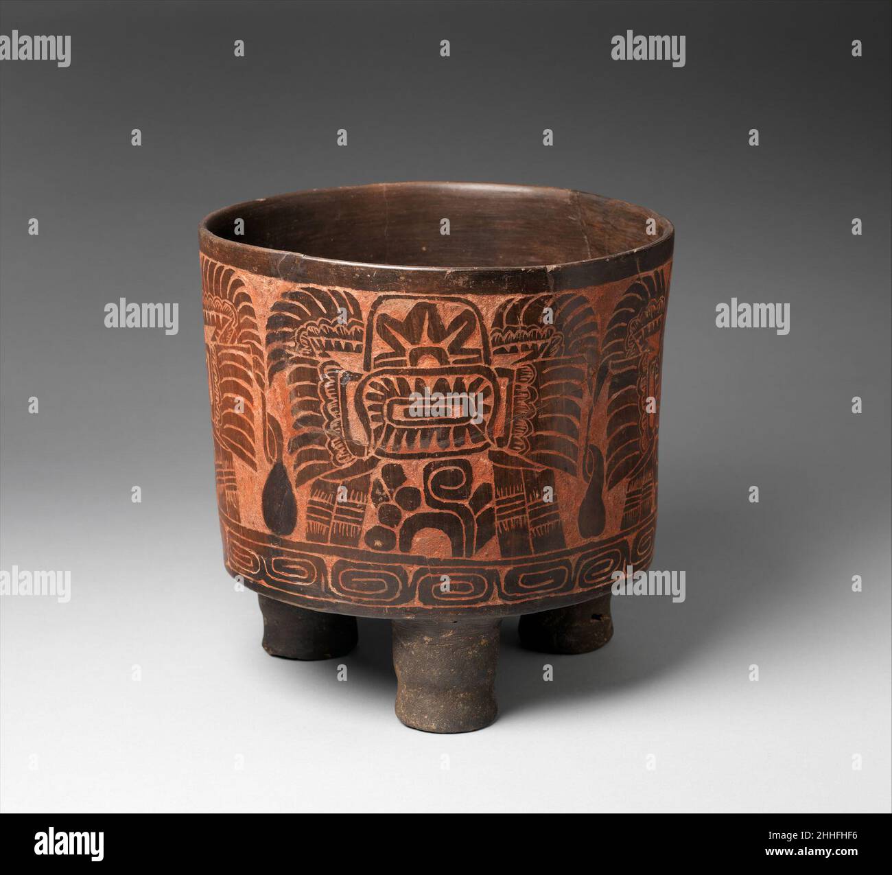 Treppiede vaso 4th–5th secolo Teotihuacan tre piedi cilindrici sostengono questo grande vaso marrone, la superficie del quale è stato scolpito in basso rilievo e accentuato con pigmento rosso. Intorno al corpo della nave, ci sono tre icone che gli studiosi hanno interpretato come un tipo di costruzione geroglifica, anche se il suo contenuto rimane indecifrato. Il motivo assomiglia a un grande headdress sfumato, con un medaglione al centro coronato da una forma a stella sulla sommità di un simbolo noto come “occhio rettile”. Questi simboli possono rappresentare titoli reali o nomi di luogo nel linguaggio visivo di Teotihuacan. Un wid Foto Stock