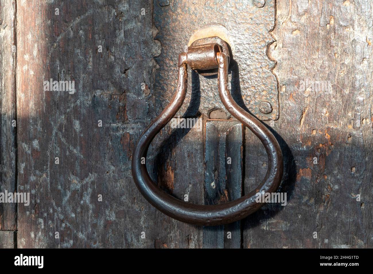 Maniglia per porta in metallo per impieghi pesanti su una vecchia porta in legno Foto Stock