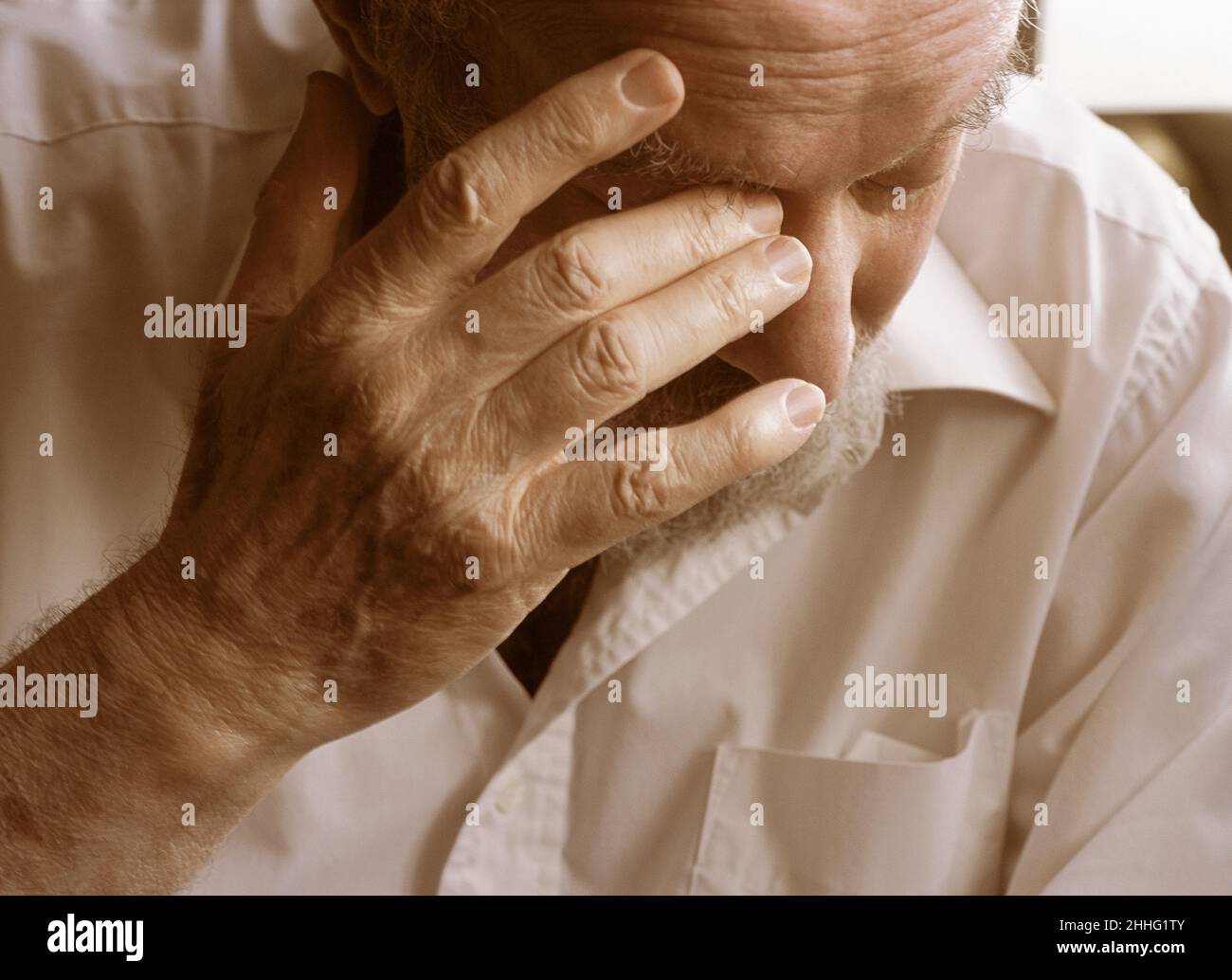 Invecchiamento, ansia ed emozione per la salute. Uomo anziano da solo con la mano in faccia. Ritratto di un caucasico maturo e stanco serio anziano nel profondo del pensiero. Foto Stock