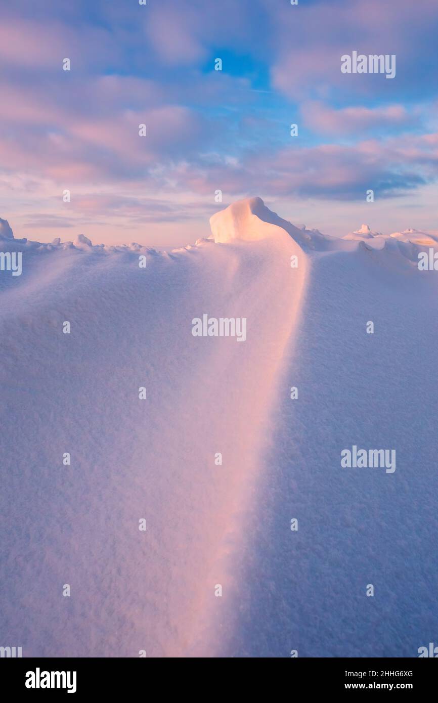 Onde nevicate al tramonto, luce porpora della sera in inverno con molta neve, immagine verticale Foto Stock