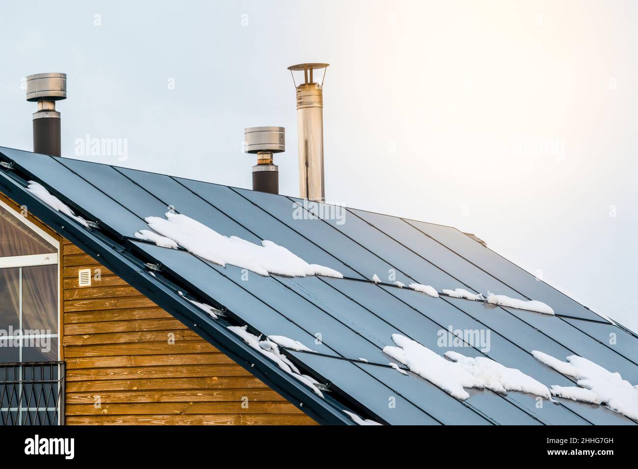 Pannelli solari su un tetto di una casa. Concetto di energia rinnovabile. Energia ecologica e pulita. Energia verde. Celle solari fotovoltaiche con neve durante wi Foto Stock