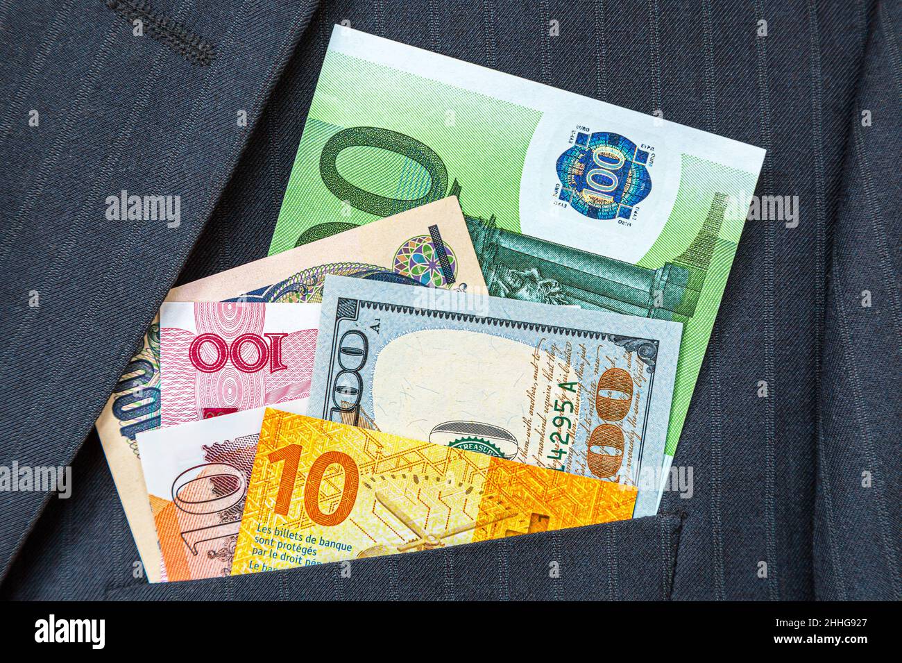 Banconote di varie valute in tasca vestito da uomo d'affari. Soldi in tasca del vestito di affari. Valuta mondiale Foto Stock