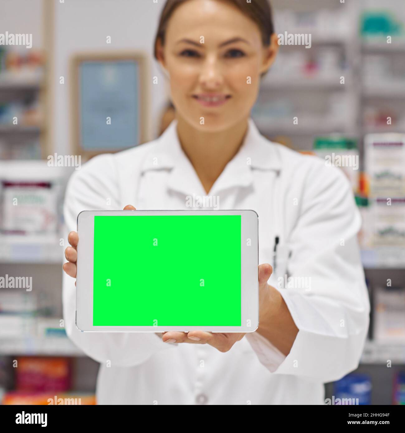 Il trattamento che state cercando. Ritratto di un'attraente farmacista che tiene in mano un display tablet digitale vuoto. Foto Stock