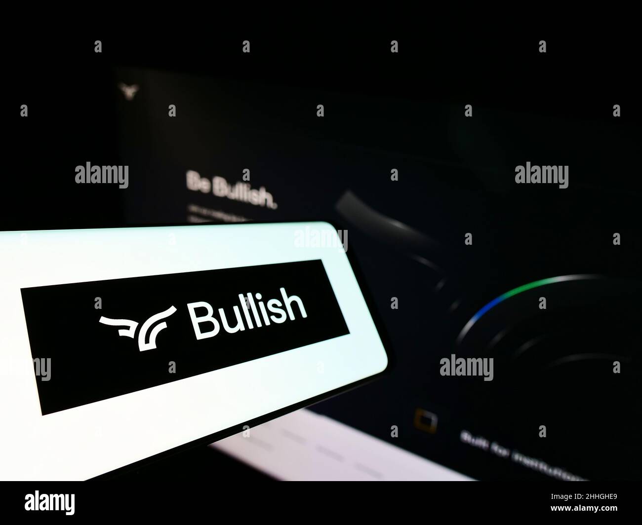 Smartphone con logo della società di scambio criptovaluta Bullish Global sullo schermo di fronte al sito web. Messa a fuoco al centro-sinistra del display del telefono. Foto Stock