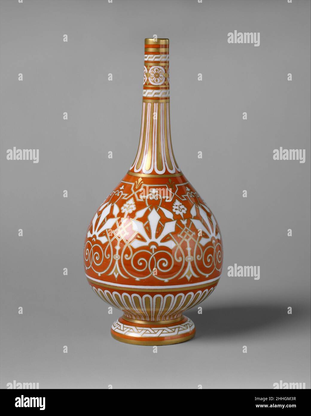Bottiglia ca. 1862 Design attribuito a Christopher Dresser britannico, scozzese il modello centrale di scorrimento interlacciato fogliame in arancio orlato in oro su una terra bianca guarisce indietro a motivi decorativi islamici spesso trovati sulla ceramica. I disegni verticali sul collo e sotto la ciotola della bottiglia sono in imitazione di fluting e di gadrooning trovati frequentemente su hollowware d'argento. La forma bulbosa del vaso, con un collo alto e stretto, si ispira agli esempi persiani e cinesi. Attribuito a Christopher Dresser (1834–1904), lo schema decorativo del vaso segue la sua idea Foto Stock