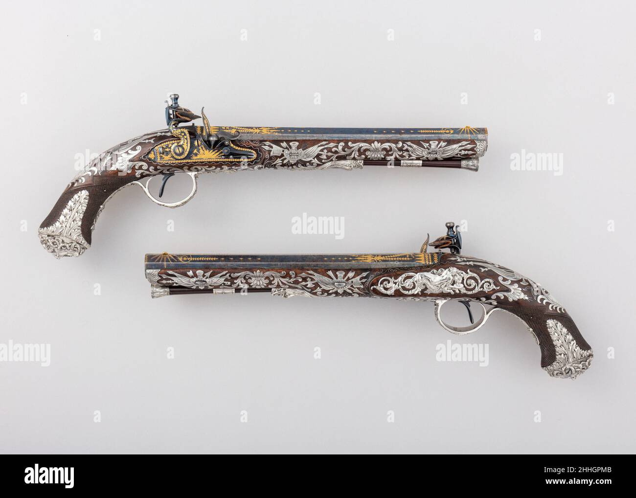 Coppia di pistole Flintlock con la scritta 1800–1801 Samuel Brunn British queste pistole si classificano tra le più sontuosamente abbellite armi da fuoco neoclassiche inglesi conosciute. Sono i capolavori di Samuel Brunn, uno dei principali tagliatori e artiglieria londinesi che ha tenuto appuntamenti con il Principe di Galles (in seguito il Principe Regente e il Re Giorgio IV, 1760–1830) e con altri membri della famiglia reale, nonché con il Consiglio d'Ordnanza del governo. Le botti e le serrature sono in acciaio blu inciso e oro intarsiato con trofei di braccia e fogliame. La decorazione degli stock, combinando incisa foglio-argento i Foto Stock