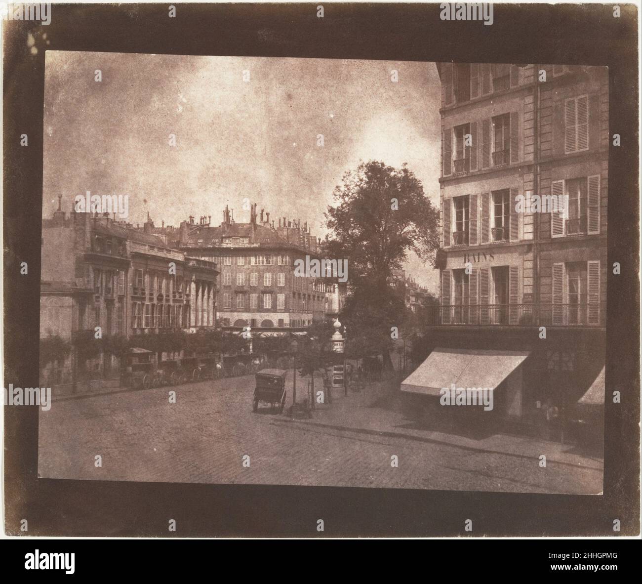 I Boulevards a Parigi Maggio-Giugno 1843 William Henry Fox Talbot British Talbot si recò a Parigi nel maggio 1843 per negoziare un accordo di licenza per i diritti francesi al suo processo di calotipo brevettato e, con Henneman, per dare istruzioni di prima mano nel suo uso al licenziatario, il marchese di Bassano. Senza dubbio entusiasta di viaggiare sul continente con una fotocamera fotografica per la prima volta, Talbot ha colto l'occasione per realizzare la fantasia che aveva immaginato per la prima volta sulle rive del Lago di Como dieci anni prima. Anche se i suoi accordi di affari alla fine non hanno dato alcun guadagno, il punto di vista di Talbot di Th Foto Stock