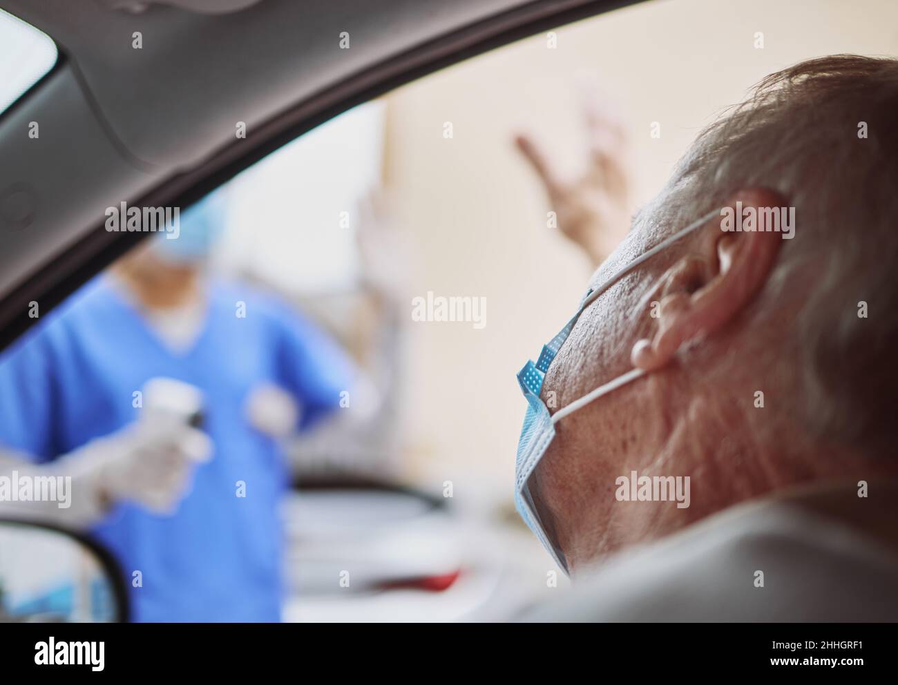 Grazie per il servizio rapido. Sparato di un uomo anziano che agita a un operatore sanitario mentre si trova in auto in un viaggio attraverso il sito di vaccinazione. Foto Stock