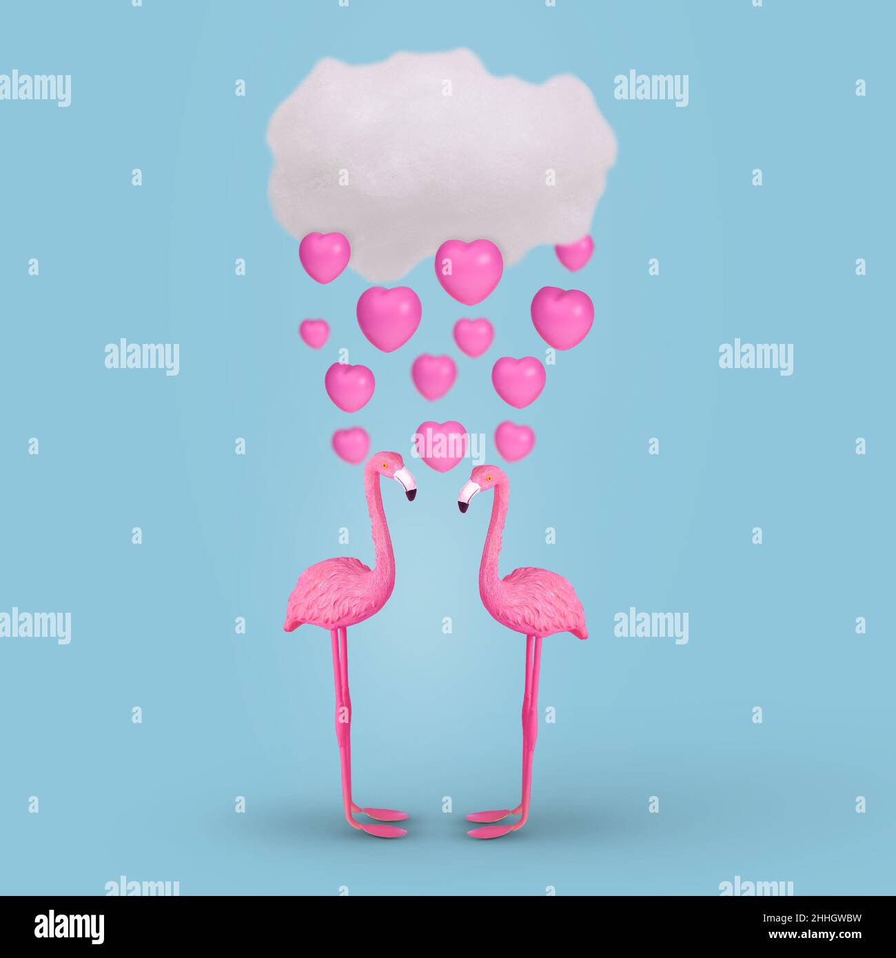 Nuvola con la pioggia rosa del cuore e un paio di fenicotteri innamorati su sfondo blu brillante. Idea creativa. Concetto minimo di amore. San Valentino o romano Foto Stock