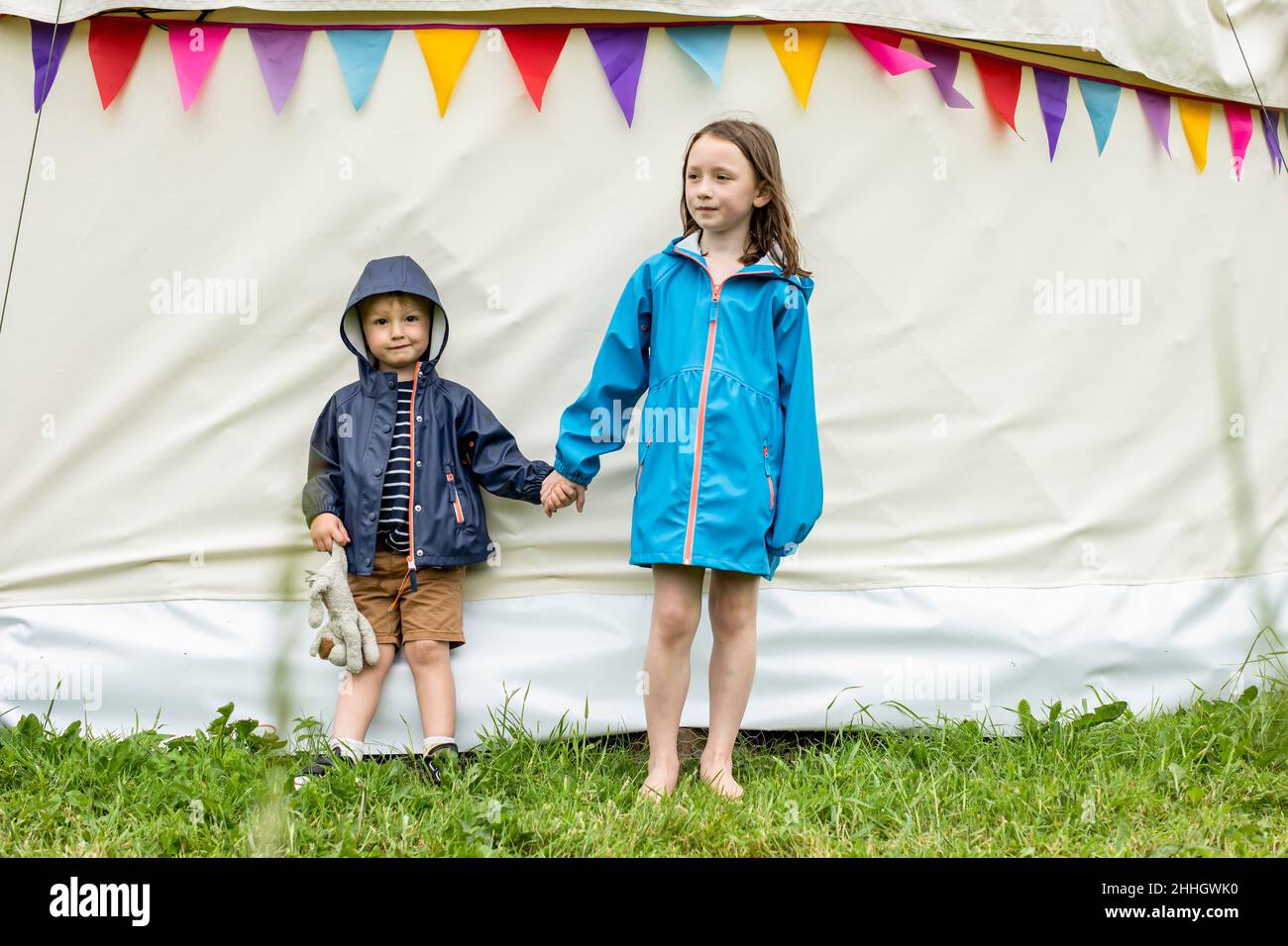 Sorella e fratello che tengono le mani fuori dalla tenda Foto Stock