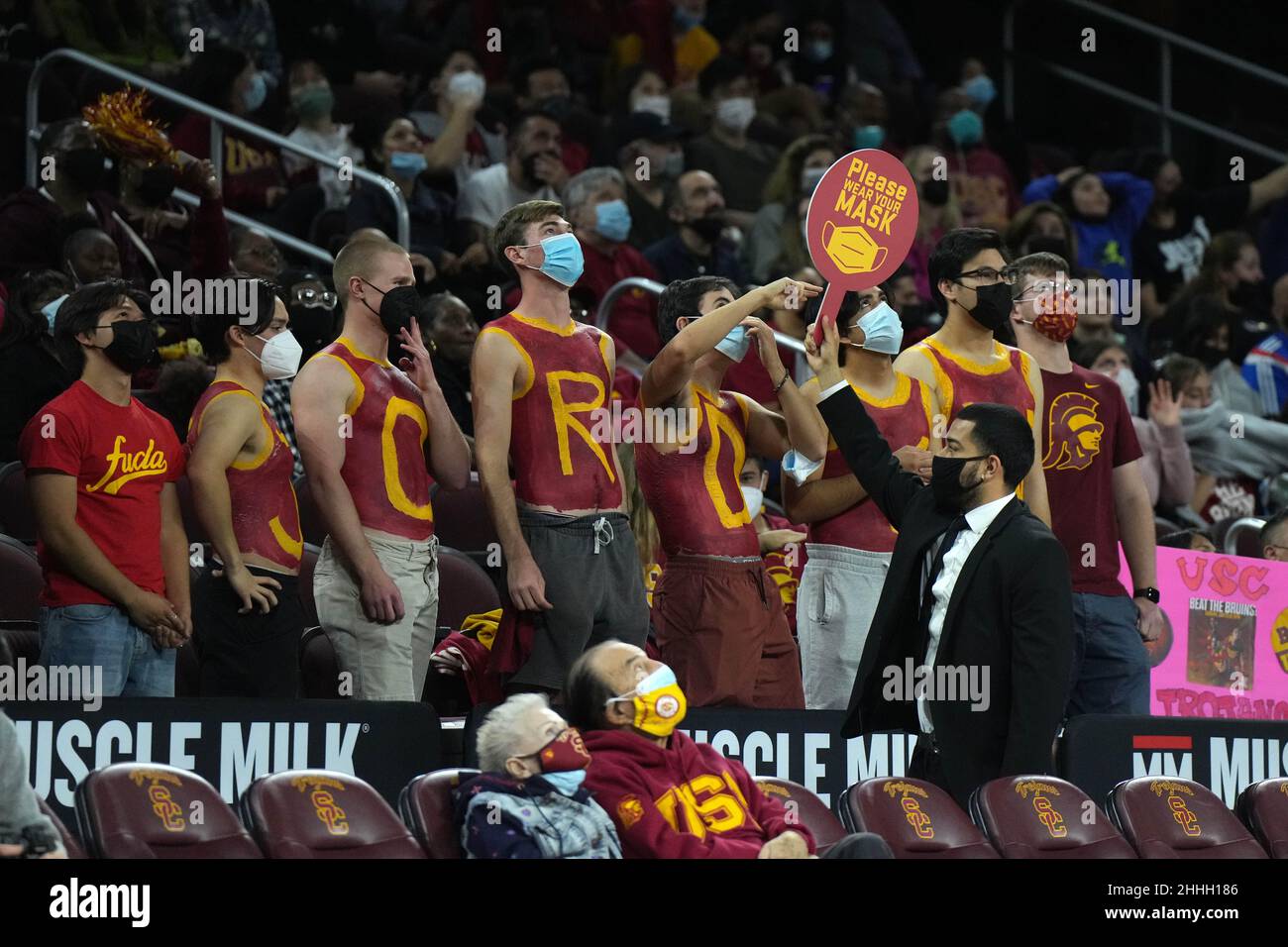 Un usciere tiene una "Please wear a face mask" durante una partita di basket femminile del college NCAA tra gli UCLA Bruins e i Southern California Trojans con capacità limitata a causa di un'ondata della variante COVID-19 omicron, domenica 23 gennaio 202, a Los Angeles. Foto Stock