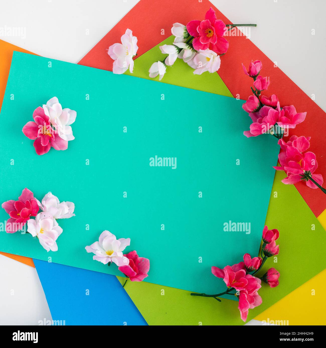 Uno sfondo quadrato che biglietto d'auguri con elementi rettangolari colorati, lungo il bordo di fiori bianchi e rosa. Spazio libero per testo o immagine in t Foto Stock