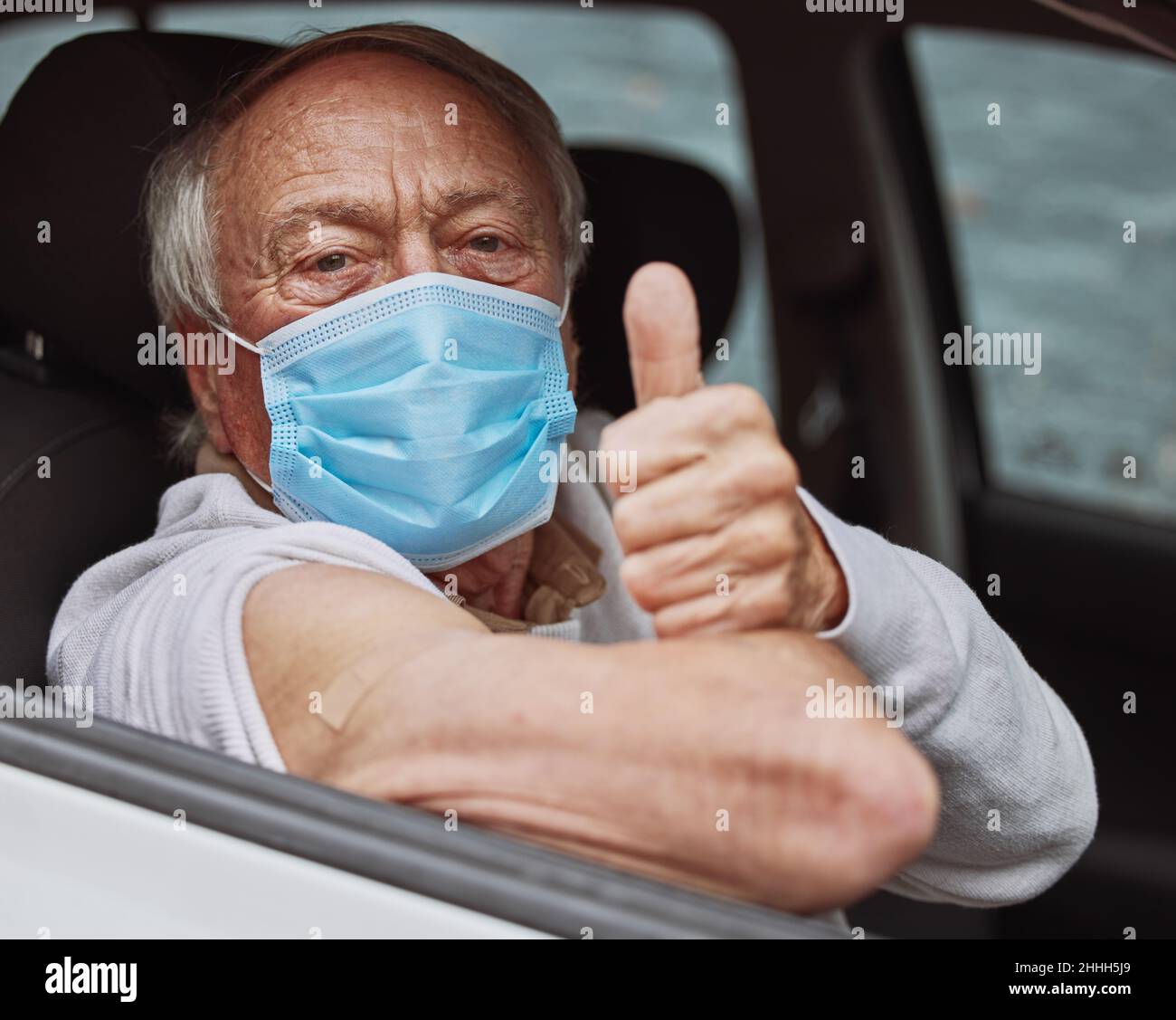Non era così male. Colpo di un uomo anziano che mostra un pollice in su nella sua automobile ad un azionamento attraverso il luogo di vaccinazione. Foto Stock