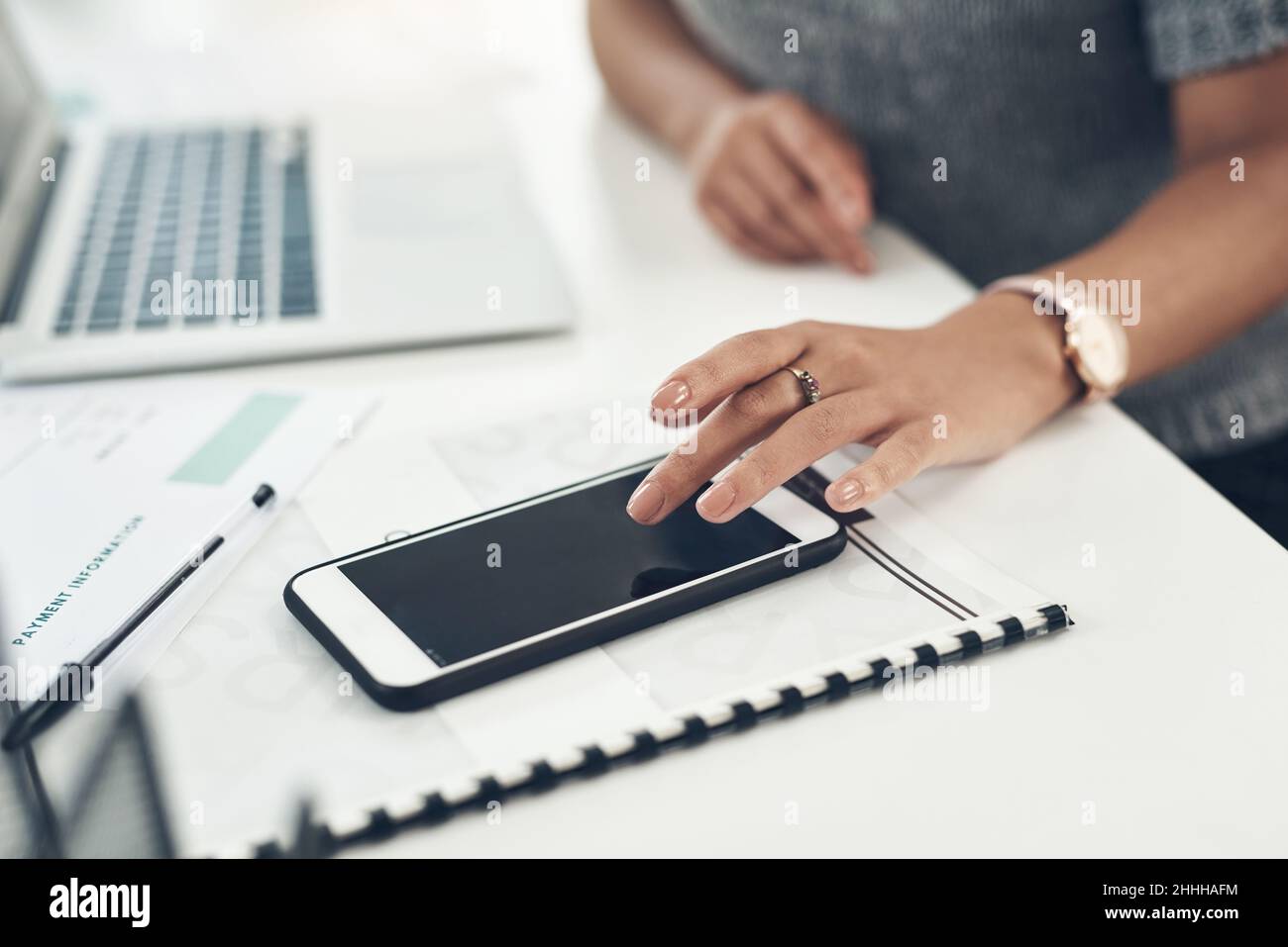 Completamento delle operazioni aziendali dal telefono. Primo piano di un'irriconoscibile donna d'affari utilizzando un cellulare in un ufficio. Foto Stock