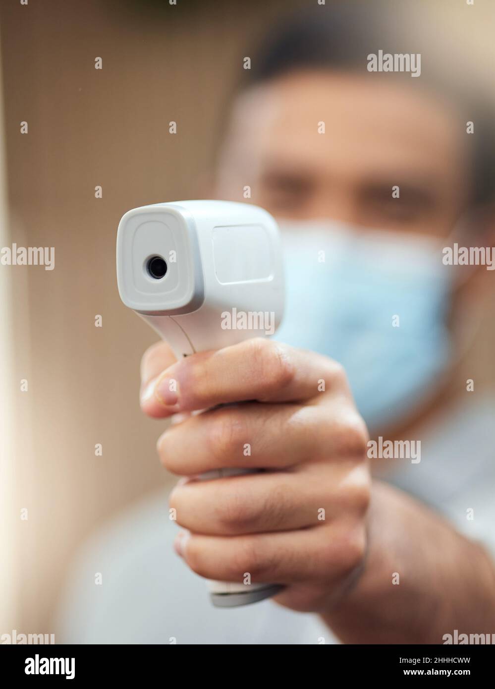 Posso ottenere la vostra temperatura. Scatto corto di un uomo irriconoscibile pronto a prendere la temperatura utilizzando un termometro digitale sul posto di lavoro. Foto Stock