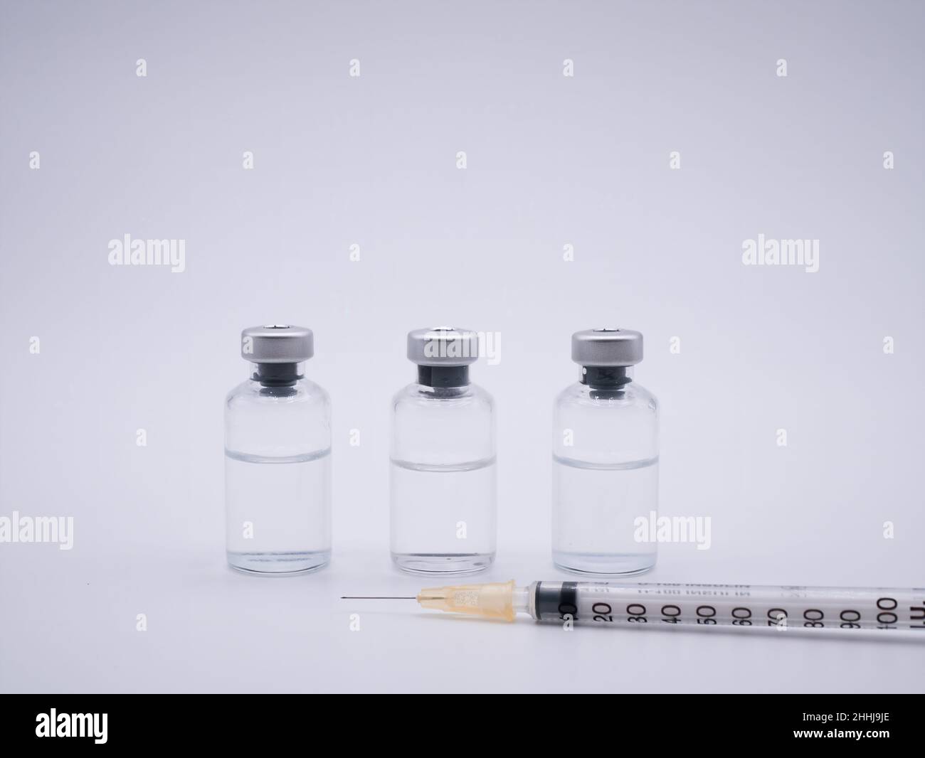 I contenitori del vaccino e la siringa sono isolati su sfondo bianco Foto Stock