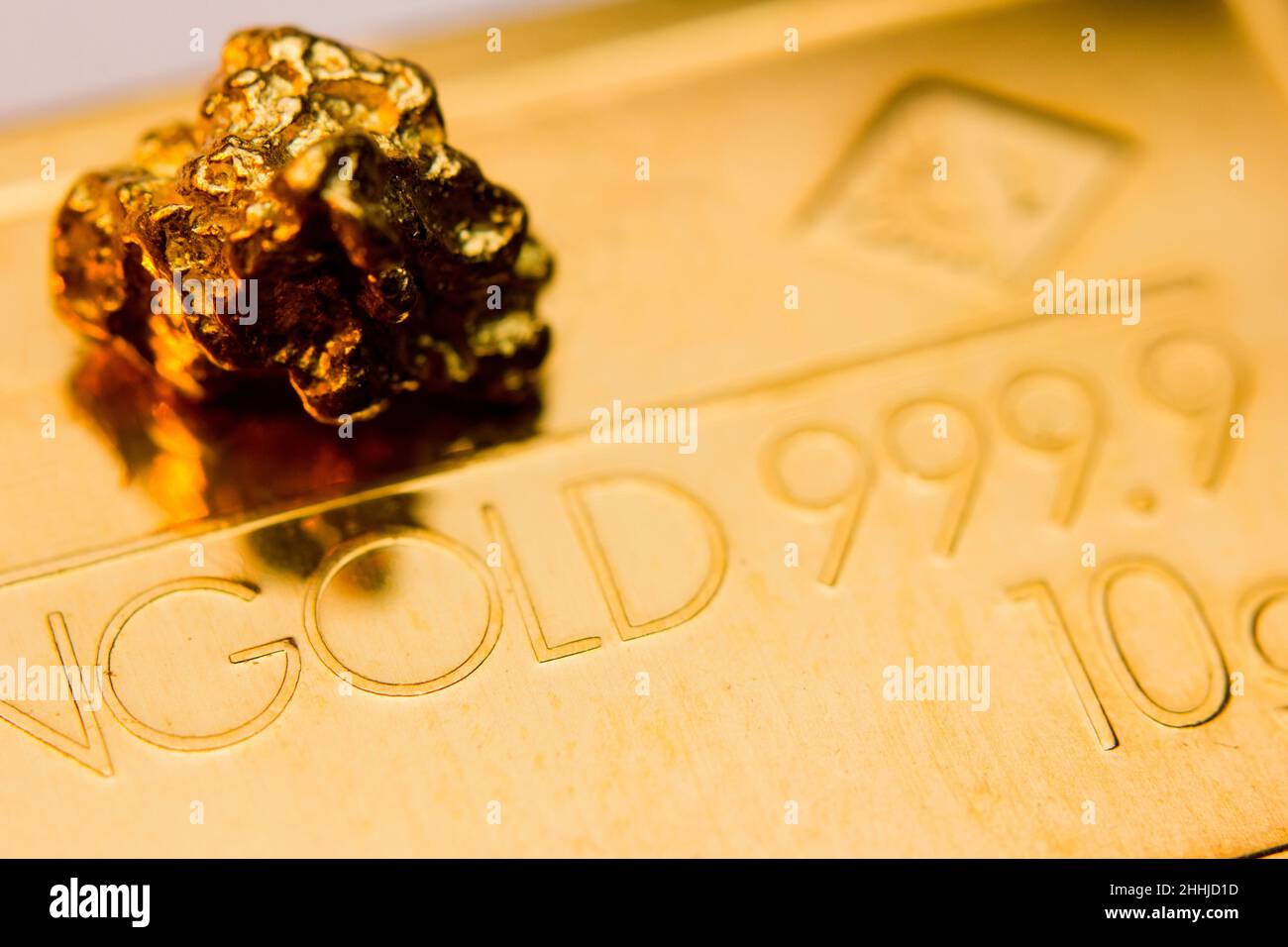 Primo piano di lingotti d'oro e un nocciolo d'oro Foto Stock