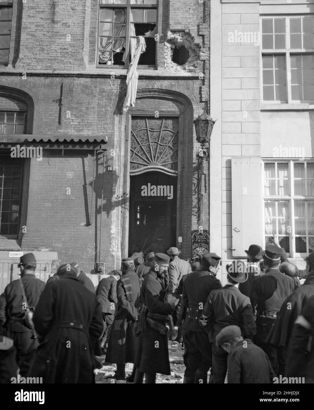 Hotel de la Noble Rose 16th secolo hotel e caffè a Furnes (Veurne) . L'hotel era utilizzato dal Re dei Belgi e dall'Esercito Belga come sede quando fu abbattuto dai tedeschi. Soldati e cittadini locali possono essere visti qui alla ricerca di shrapnel dopo l'attacco. Circa ottobre 1914 Foto Stock