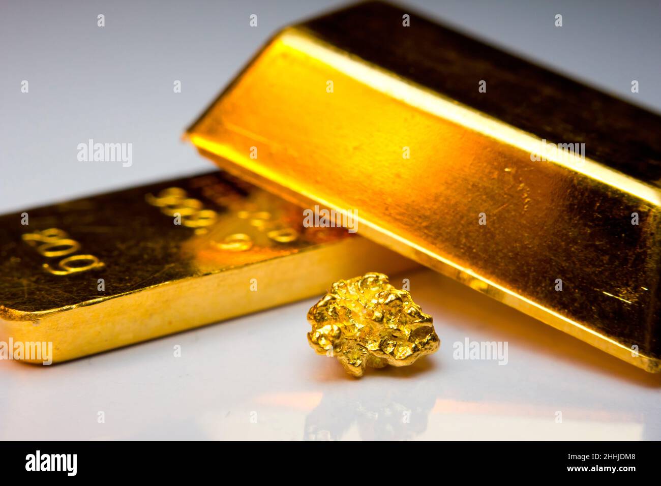 Primo piano di lingotti d'oro e un nocciolo d'oro Foto Stock