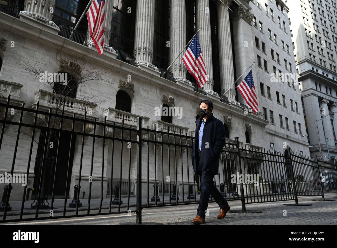 New York, Stati Uniti. 24th Jan 2022. Una luce riflessa cade su un uomo che cammina oltre la Borsa di New York a New York City, NY, 24 gennaio 2022. Sulla notizia di un possibile rialzo dei tassi di interesse da parte della Federal Reserve e le tensioni in Ucraina, le scorte sono crollate bruscamente durante il commercio mattutino, con la perdita di più di 1.000 punti del DOW, il suo giorno peggiore dai primi giorni pandemici di ottobre 2020. (Foto di Anthony Behar/Sipa USA) Credit: Sipa USA/Alamy Live News Foto Stock