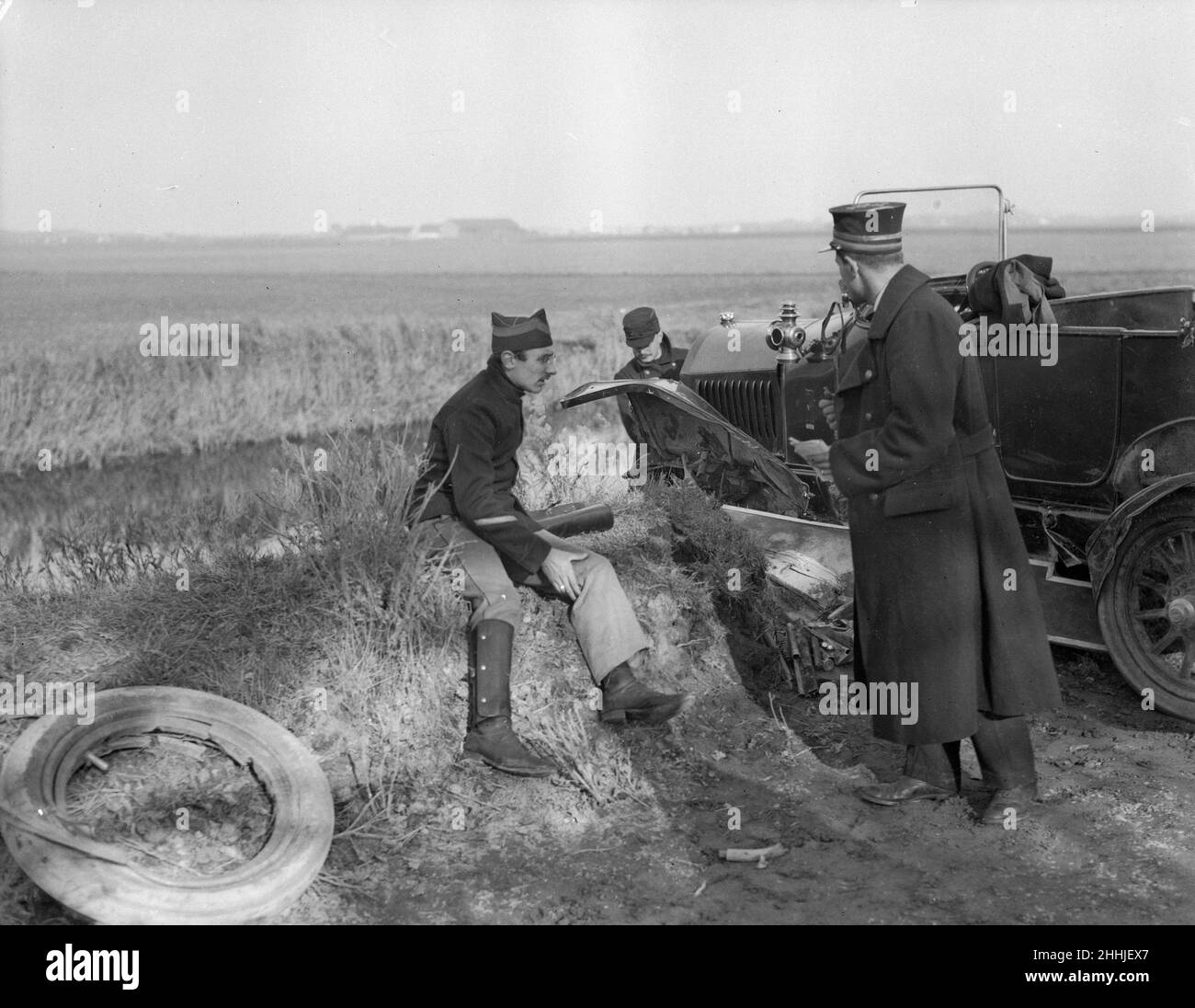 Ufficiali belgi e francesi ispezionano una macchina che si è schiantata e quasi rovesciata lungo l'argine in fossa sulla strada Veurne. Circa novembre 1914 Foto Stock