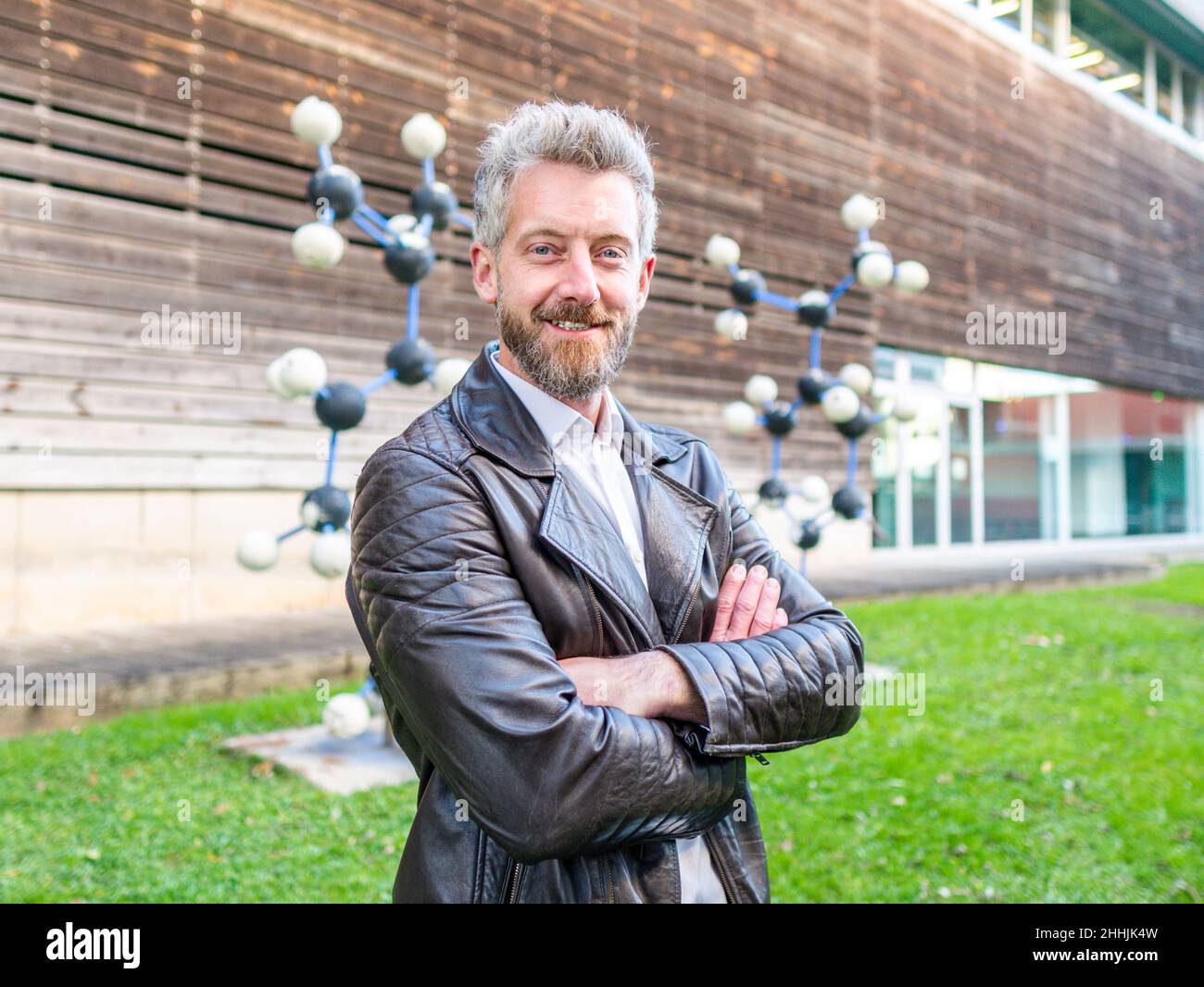 Donna contadina cura in bottiglia camicia a scacchi che alimenta cute pecora pelosa mentre lavora in fattoria shabby edificio Foto Stock