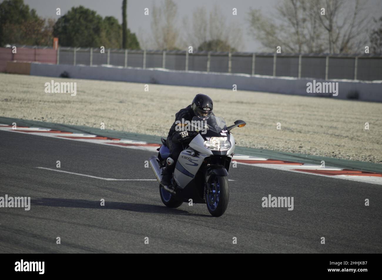 Driver su una moto sportiva grande modello BMW K1200 sul circuito in Spagna Foto Stock