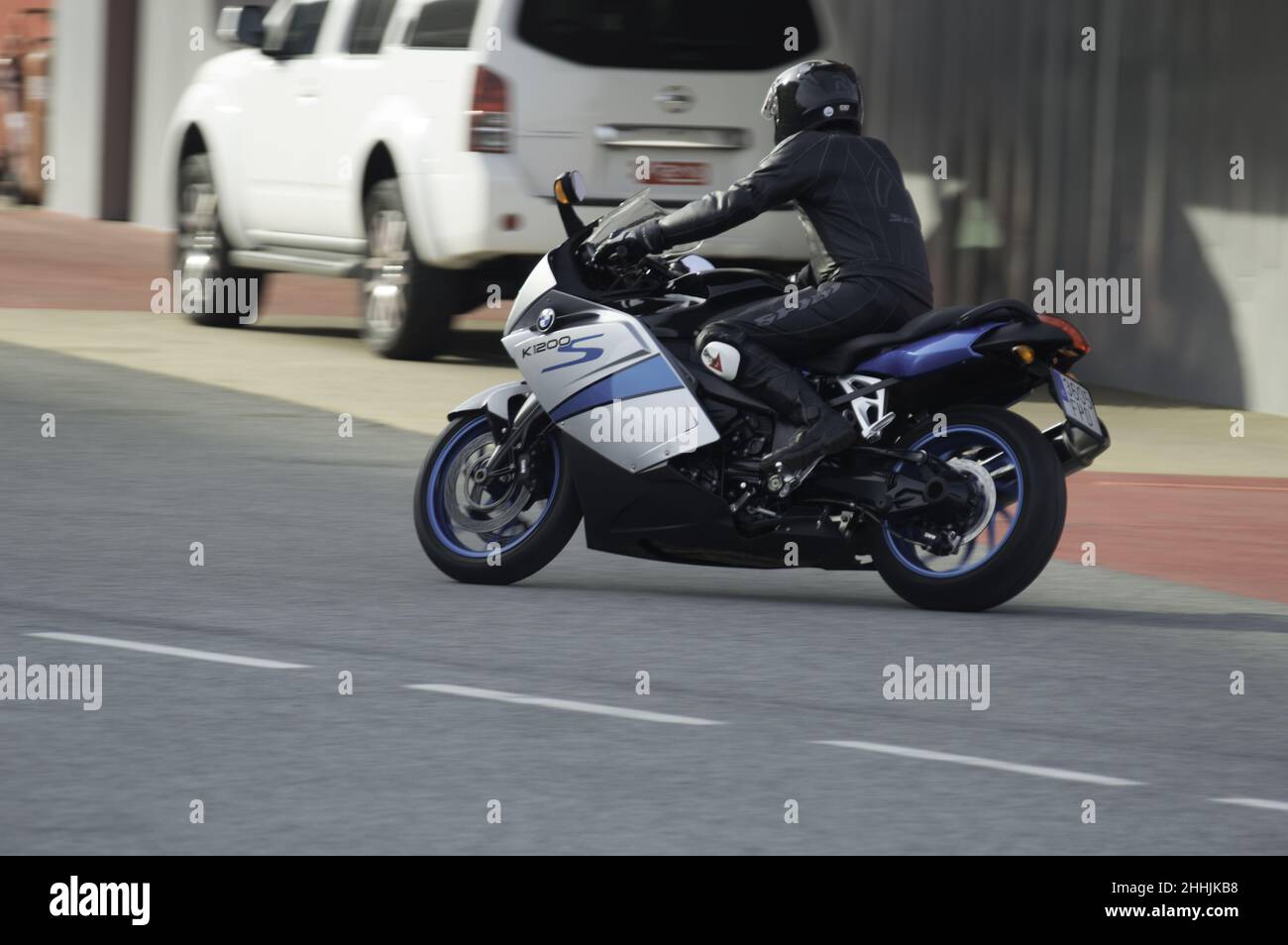 Driver su una moto sportiva grande modello BMW K1200 sul circuito in Spagna Foto Stock