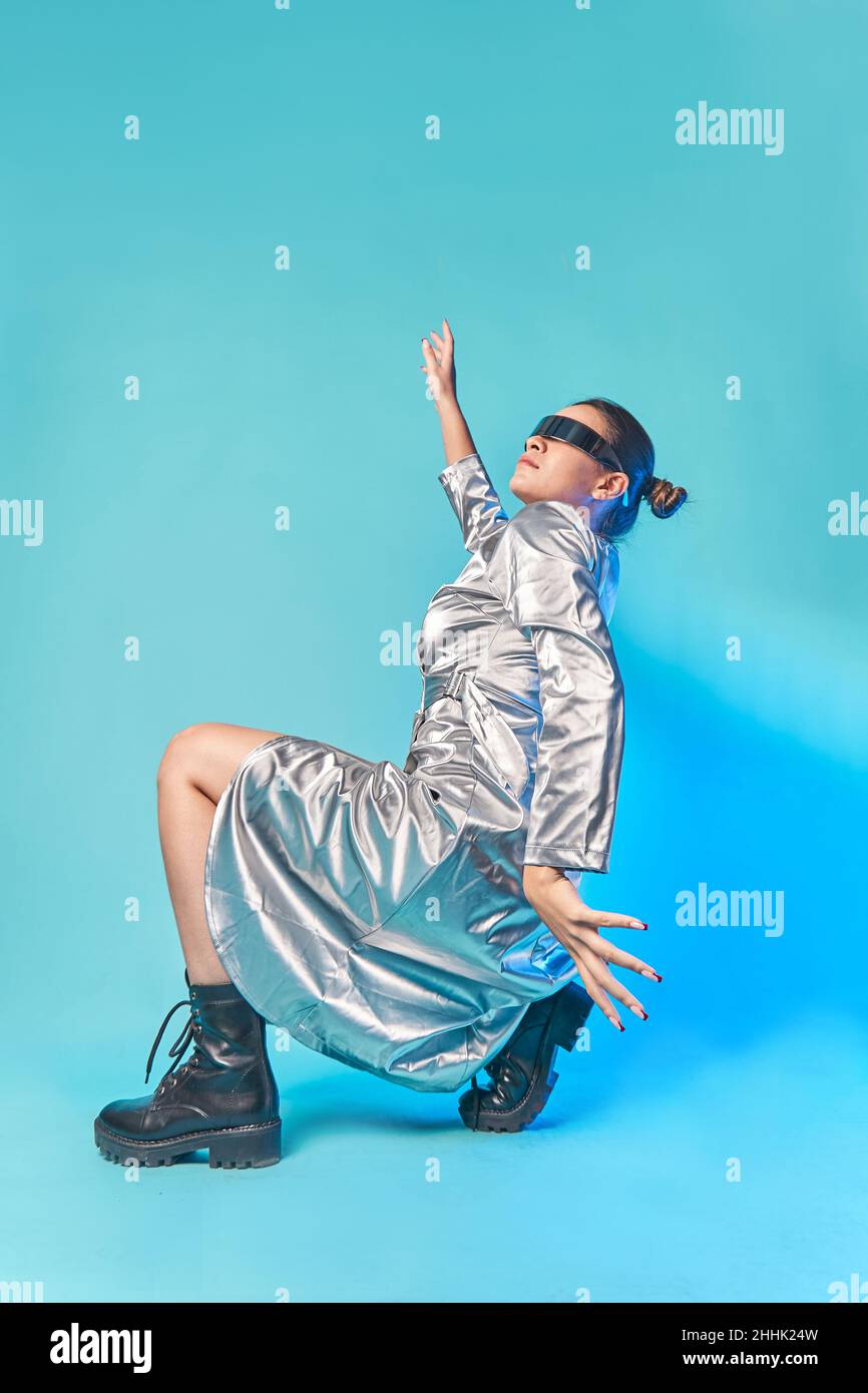 Crop anonimo seduta femminile con le gambe incrociate e mangiare dolci banane affettate mirtillo e lamponi Foto Stock