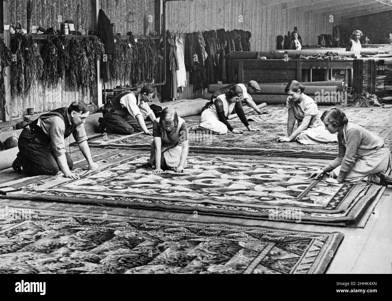 Tappeto Traders Limited, Kidderminster. Un lavoro per gli esperti nel processo di finitura. Tappeti che sono esaminati per fili di lana sciolti o pezzi di lana vaganti. 18th aprile 1933 Foto Stock