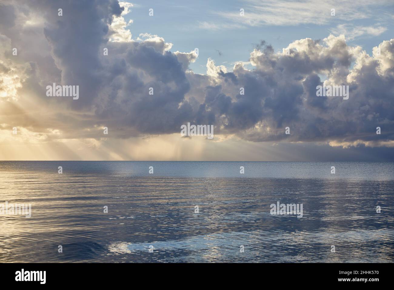 Nuvole e raggi di sole sull'oceano all'alba Foto Stock