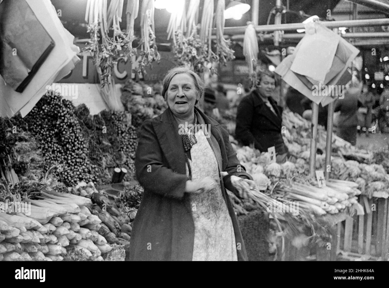 Donna che serve sul negozio alimentare verde stalla a Kingston Market. Circa 1936 Foto Stock