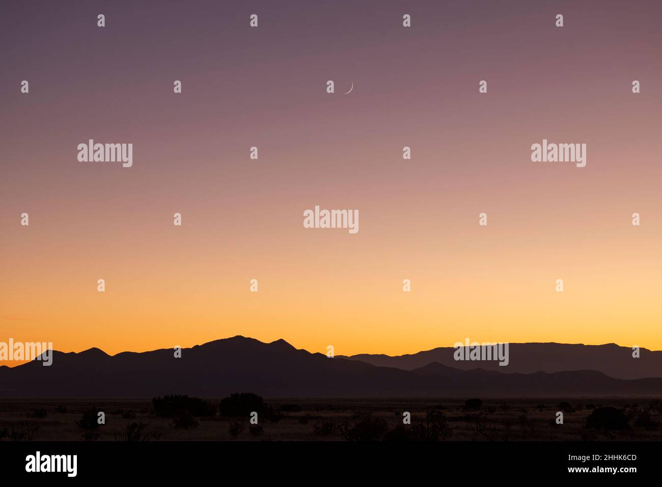 USA, New Mexico, Santa Fe, Crescent moon sopra le montagne di Jemez al tramonto Foto Stock
