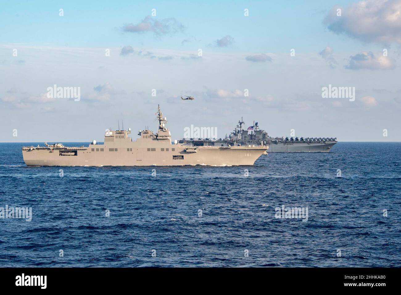 MAR DELLE FILIPPINE (Gen. 22, 2022) nave d'assalto anfibio di classe americana USS America (LHA 6), posteriore, e la forza di autodifesa marittima del Giappone (JMSDF) cacciatorpediniere di classe Hyūga JS Hyūga (DDH 181) transitano nel Mare delle Filippine, 22 gennaio 2022. Operando come parte della U.S. Pacific Fleet, le unità assegnate ai gruppi Carl Vinson e Abraham Lincoln Carrier Strike, America e Essex Amphibious Ready Groups, insieme a JMSDF, stanno conducendo corsi di formazione per preservare e proteggere una regione indopacifica libera e aperta. (STATI UNITI Foto Navy di Mass Communication Specialist 2nd Class Brett McMinoway) Foto Stock