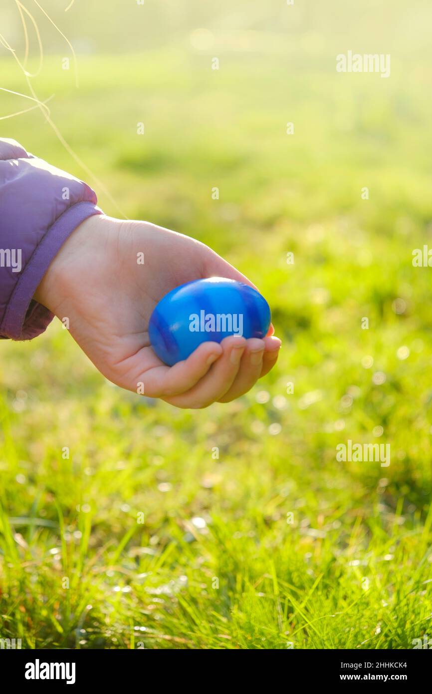 Pasqua Egg Hunt.Easter dipinse uova in mano di un bambino in un giardino di primavera al sole. Uova colorate. Vacanza di Pasqua Tradition.Spring vacanza religiosa Foto Stock