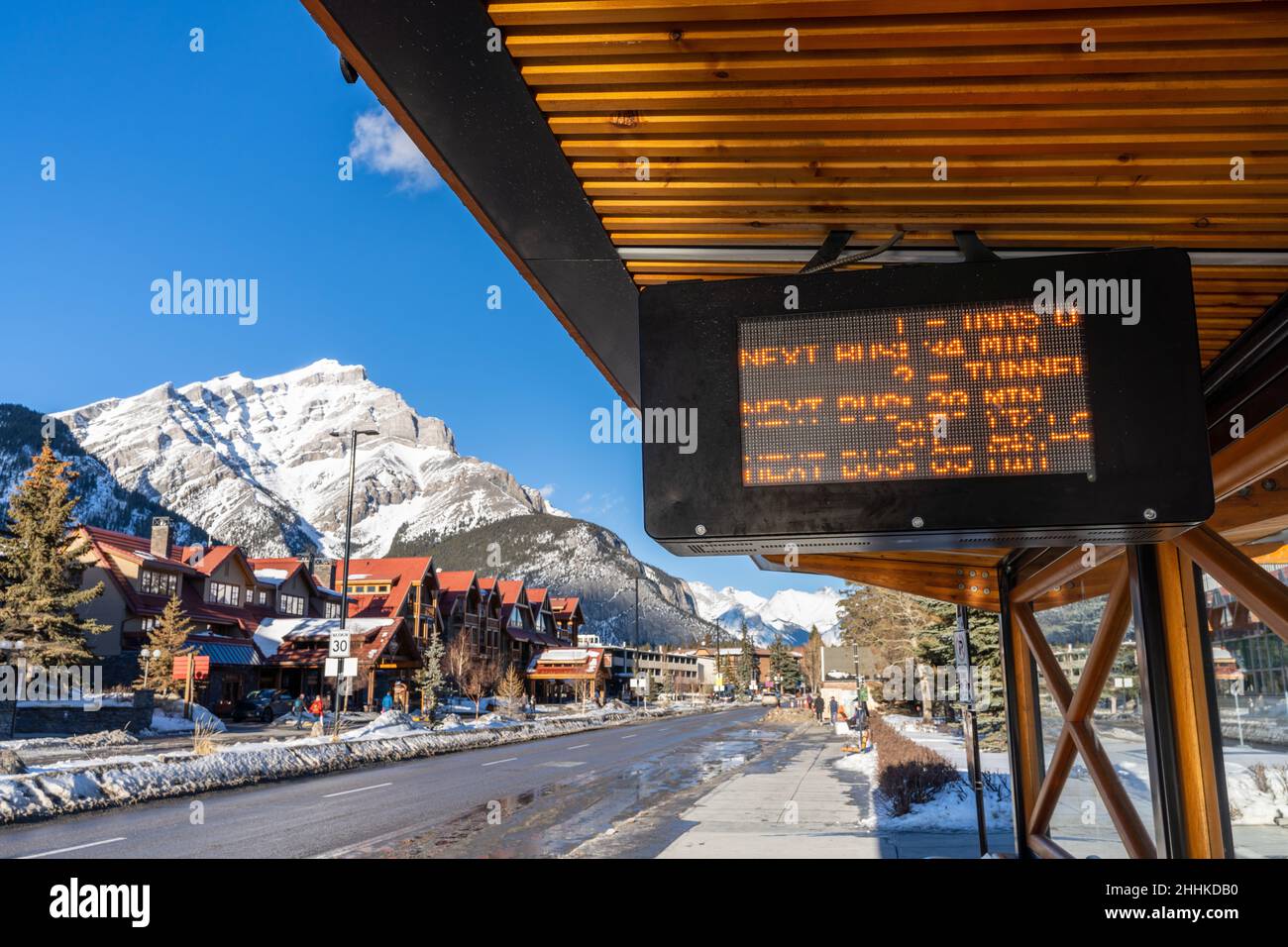 Vista sulla strada della città di Banff. Fermata dell'autobus su Banff Avenue nella stagione invernale delle nevicate. Banff, Alberta, Canada. Foto Stock