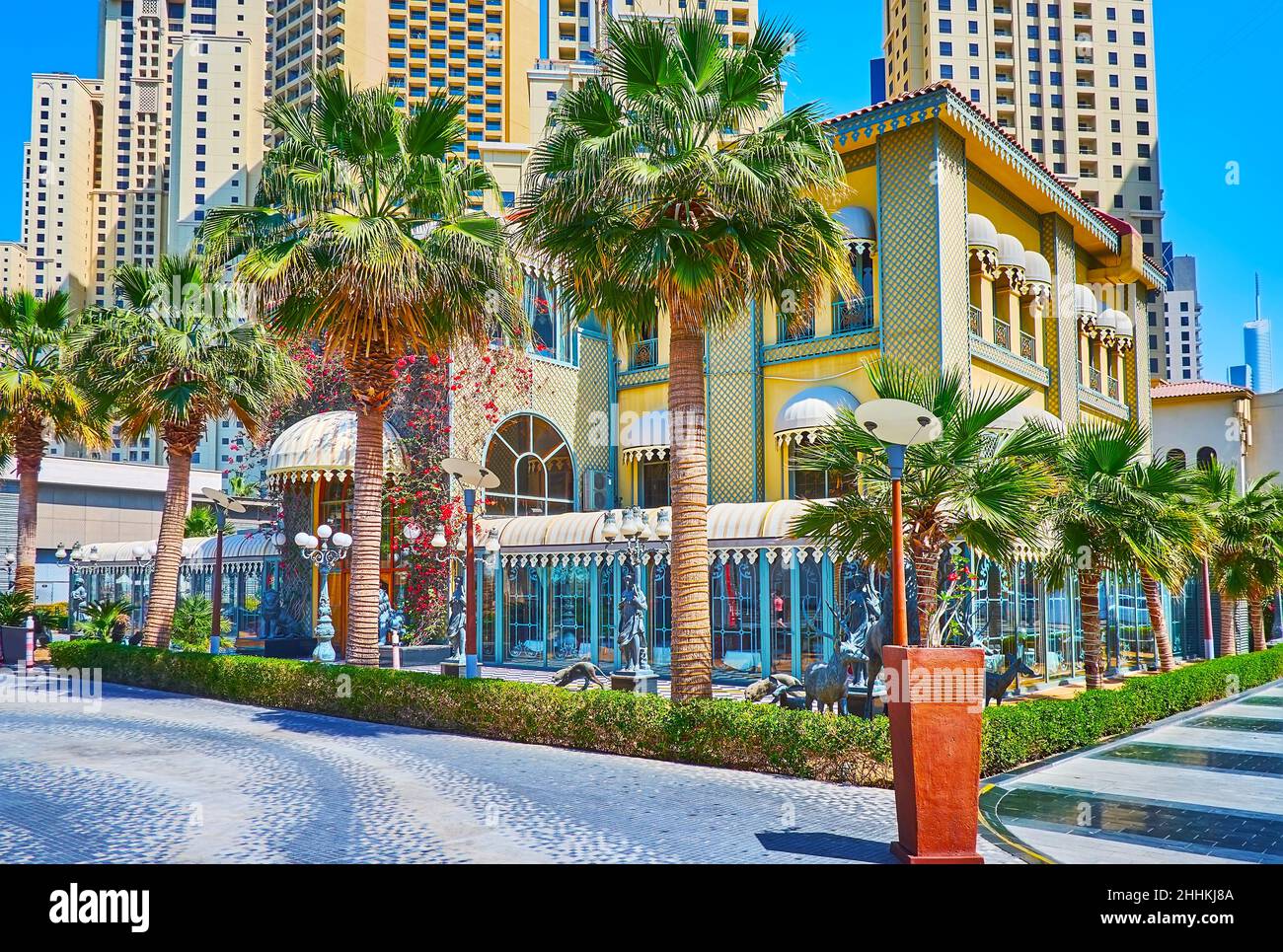 Le lussureggianti palme nascondono il palazzo in stile vintage del ristorante elegante, situato in al Mamsha Street nella zona di JBR Marina Beach, Dubai, Emirati Arabi Uniti Foto Stock