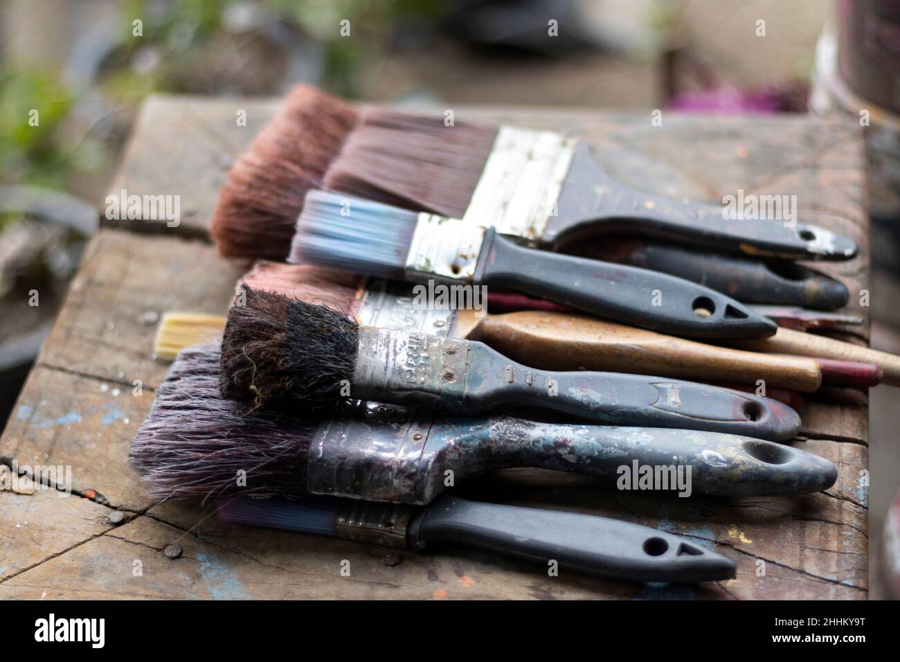Vecchie spazzole di pittura usurate che si stendono su un tavolo di legno Foto Stock