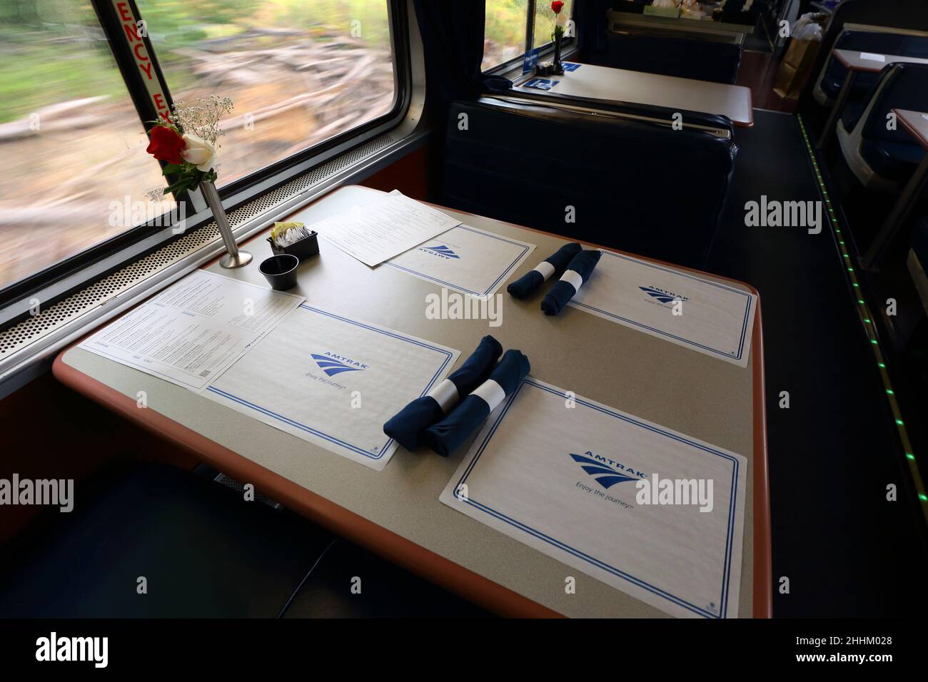 Piazzole e menu sui tavoli di un'auto da pranzo Amtrak. Foto Stock