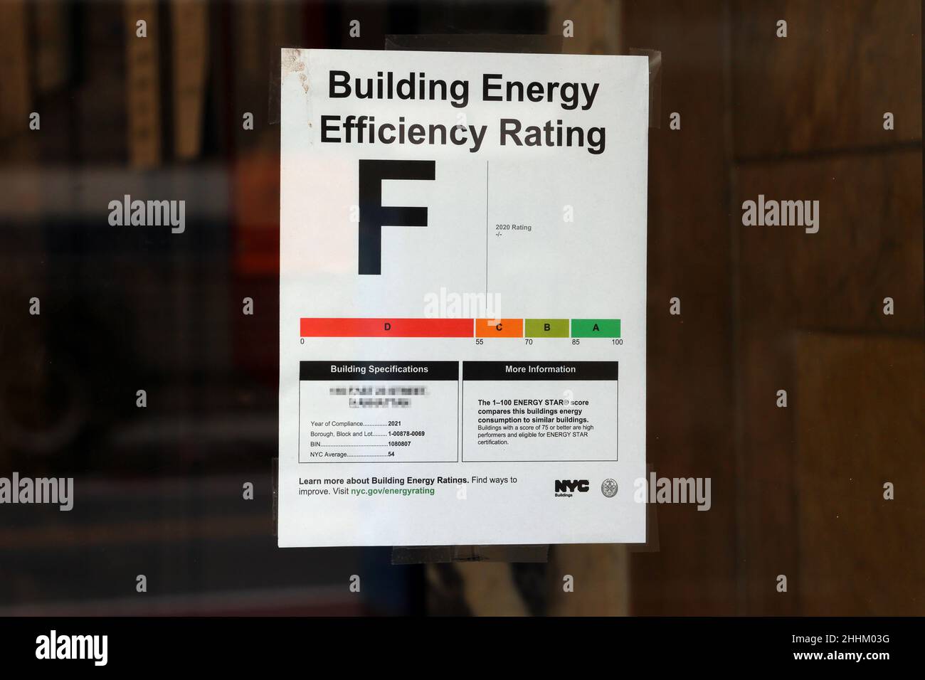 Un poster 'F' grade Building Energy Efficiency Rating con indirizzo redatto, sulla finestra di un edificio commerciale di New York City. Foto Stock