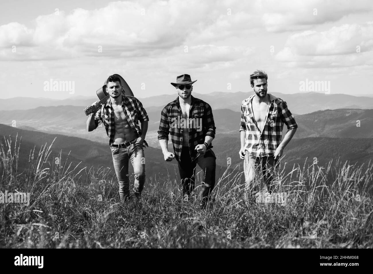 Gruppo di giovani amici escursioni in campagna. Tre uomini a piedi da sentiero escursionistico. Tre amici viaggio e avventura concetto. Femmina che ama fare escursioni Foto Stock