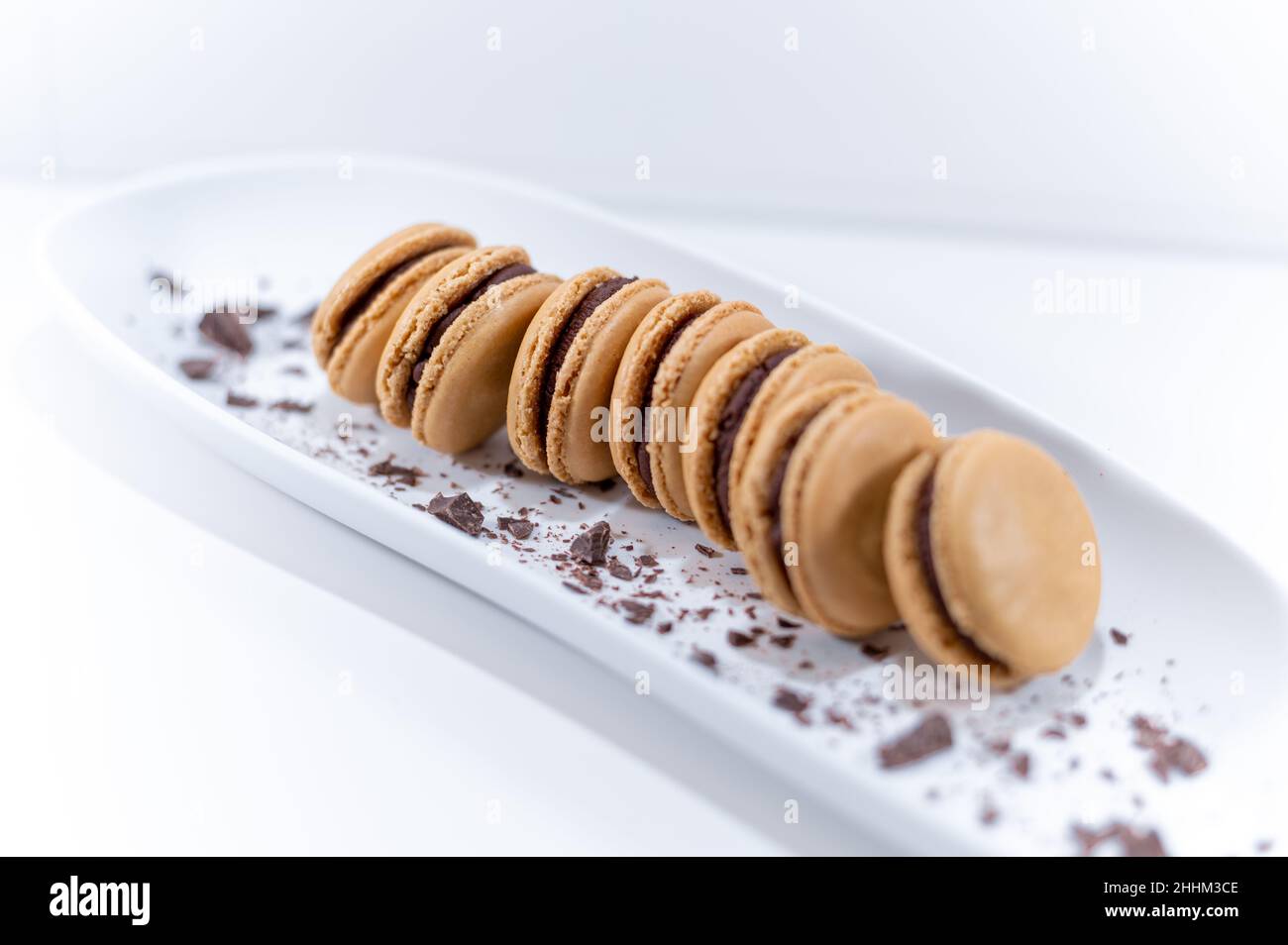 macaron al cioccolato, dessert al piatto francese bianco Foto Stock