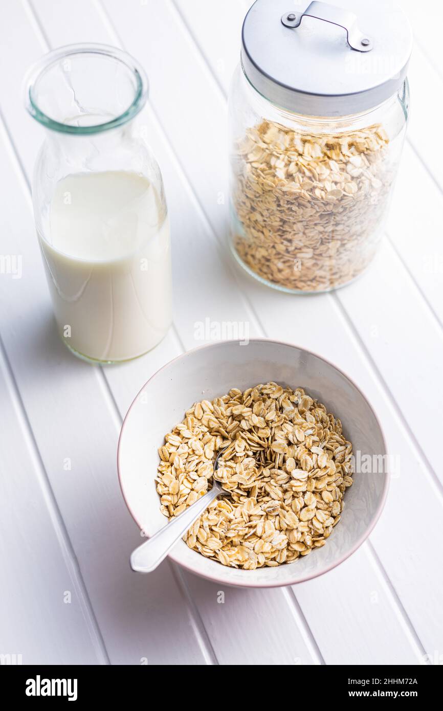 Colazione cereali. Farinata d'avena cruda. Fiocchi di avena crudi nel recipiente. Foto Stock