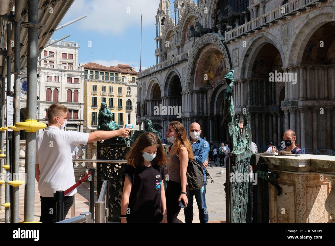 Un lavoratore controlla la temperatura dei turisti prima di entrare nella Torre di San Marco a Venezia, 20 giugno 2020. Foto Stock