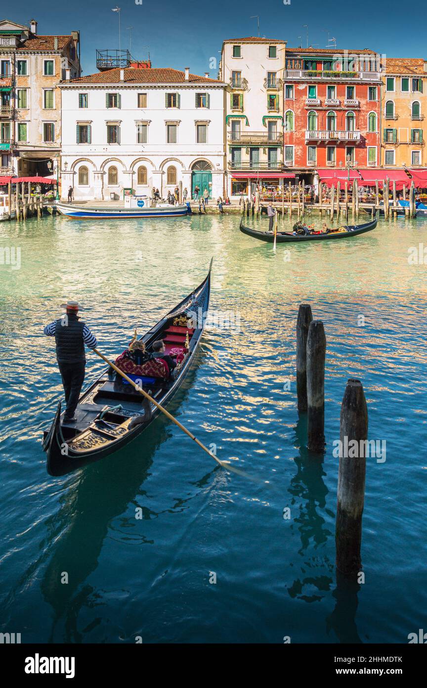 Goldoliere e gondola navigando nei canali di Venezia, Italia Foto Stock