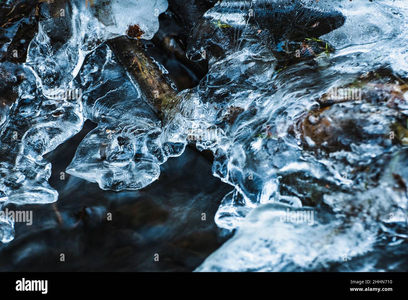 L'acqua corrente da un ruscello nella foresta ha formato la formazione di ghiaccio bella Foto Stock